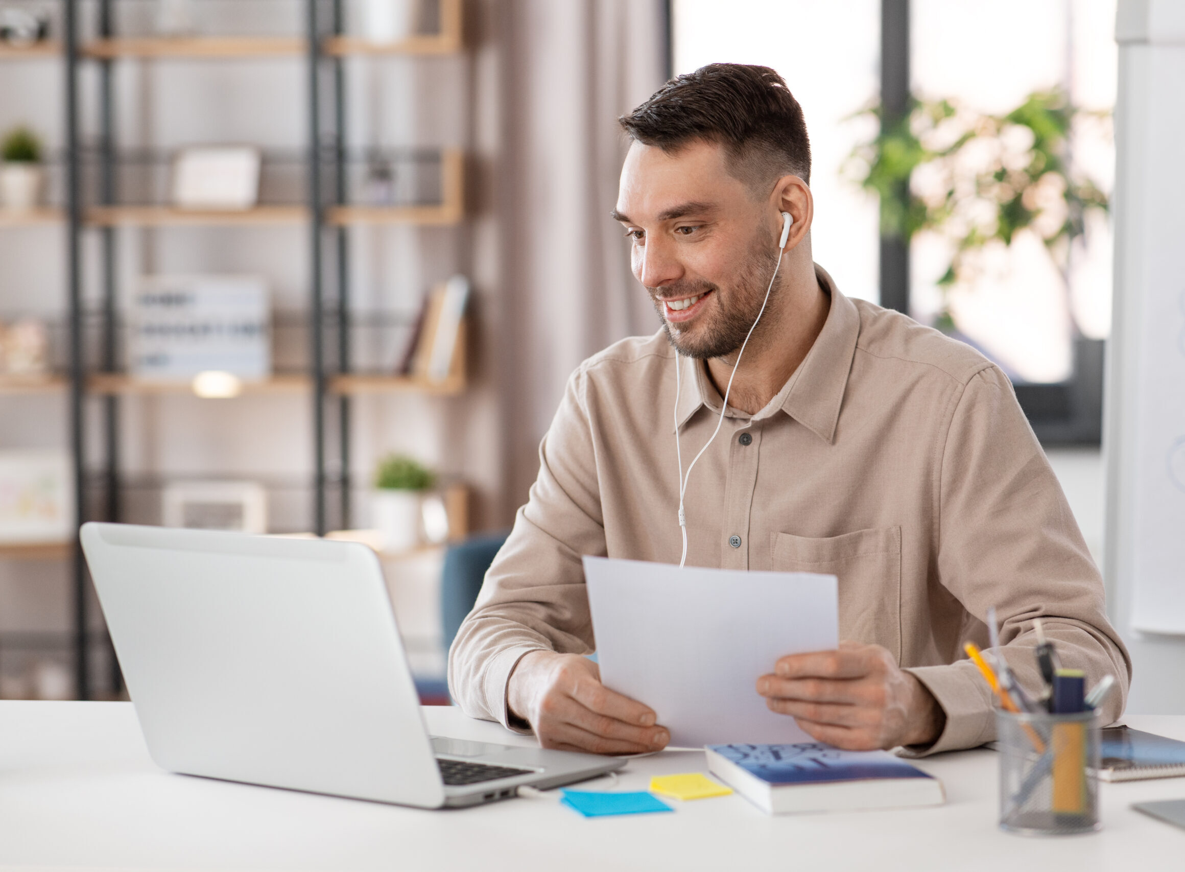 teacher with laptop and earphones working at home