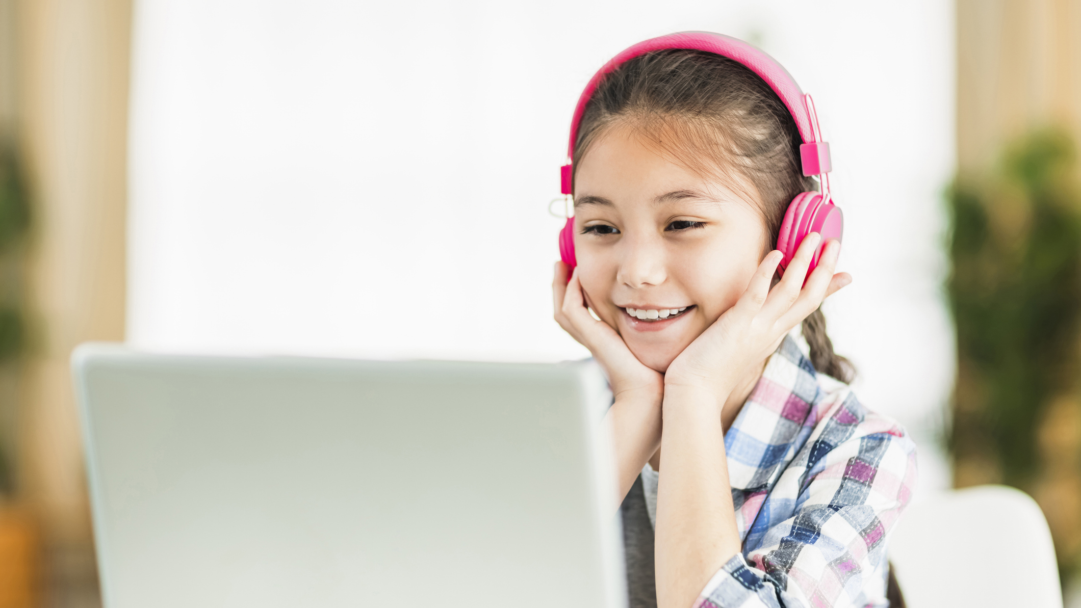 Happy student girl in headphones.Study online on laptop listening course.
